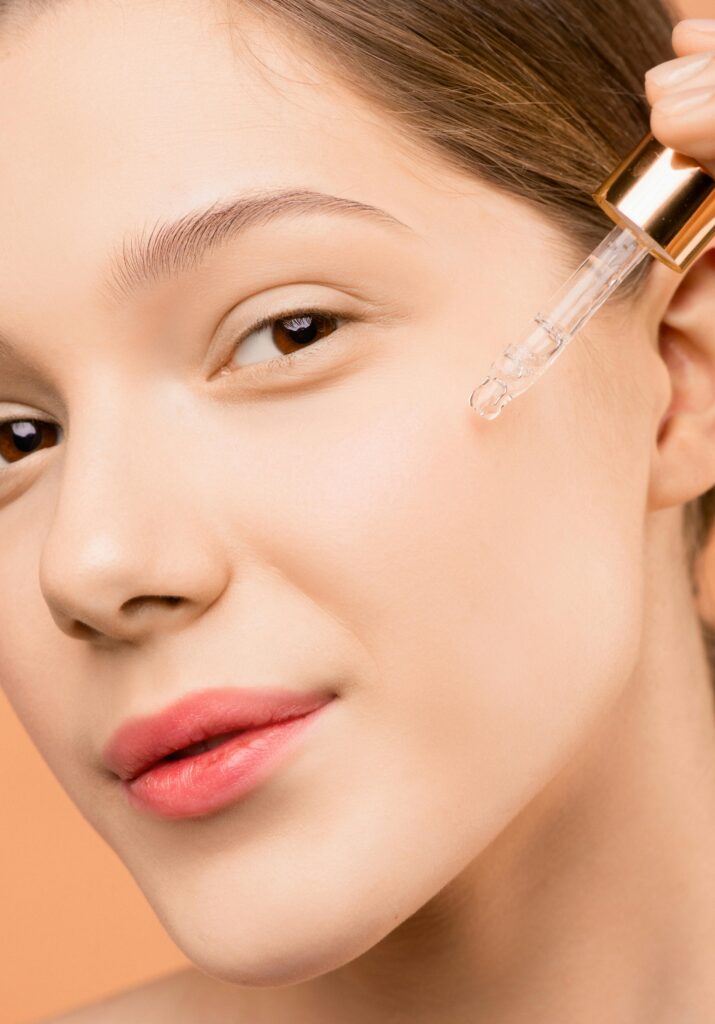 What Kind of Facial Is Best for Dry Skin? The Ultimate Guide A woman applying serum with a dropper to her face for skincare routine.